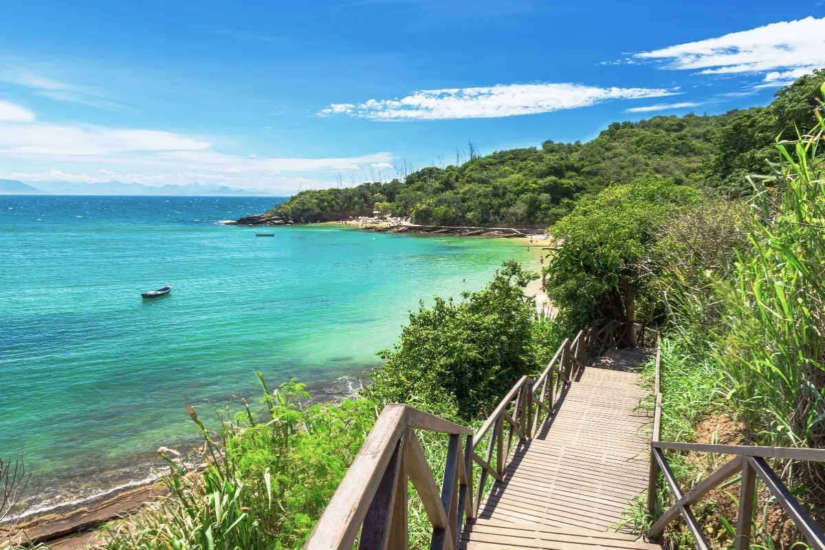 Sendero de madera hacia una playa de aguas turquesa en Búzios