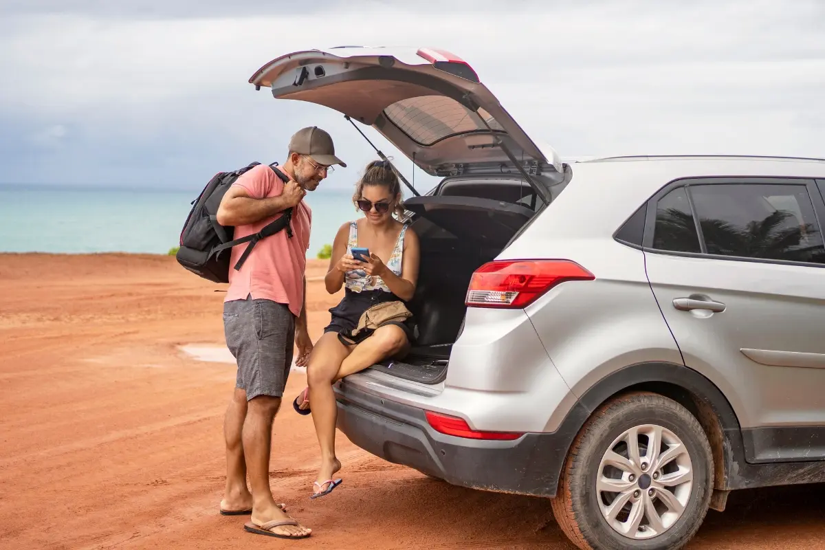 Pareja de viajeros junto a su auto alquilado explorando la isla